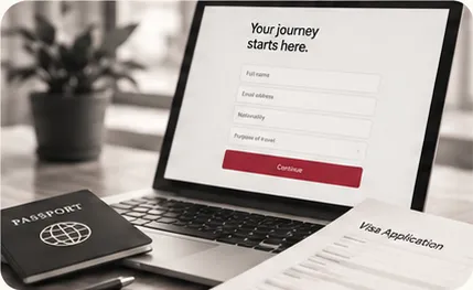 A laptop showing the online visa application form beside a passport